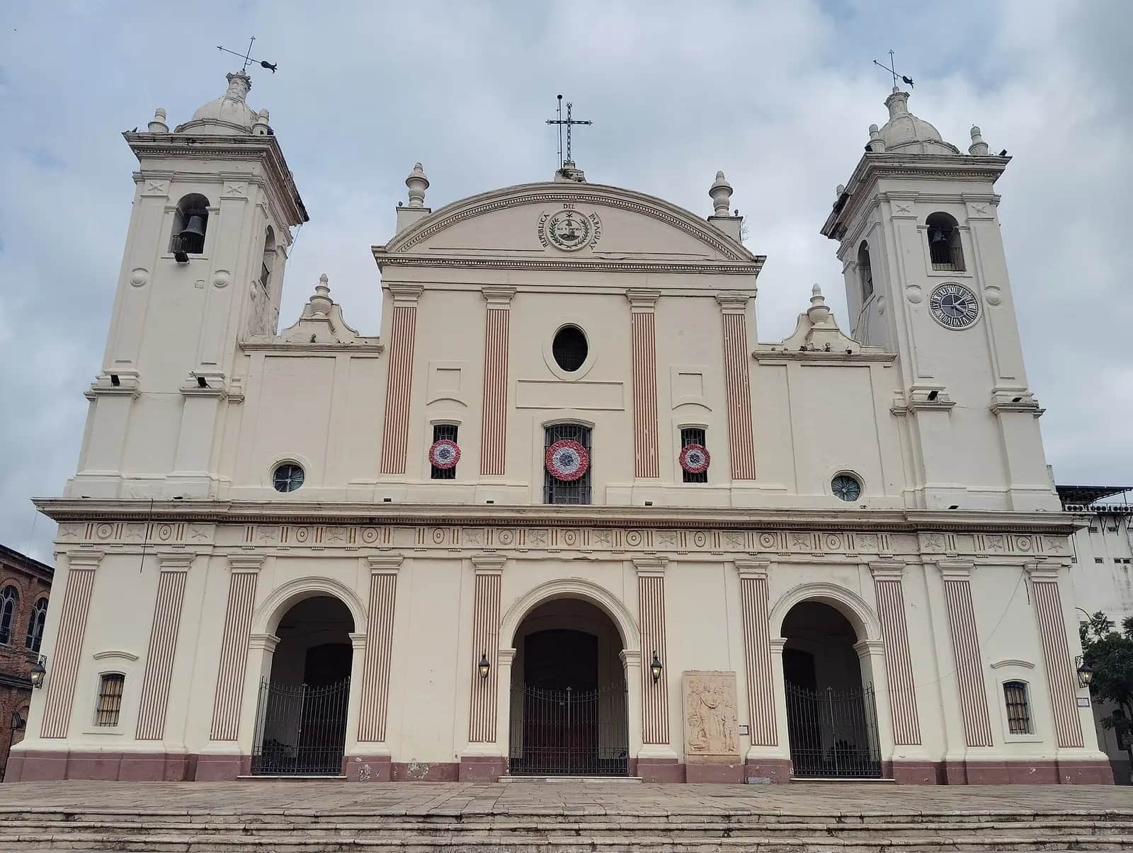 Façade blanche de la cathédrale métropolitaine d'Asunción, avec ses deux clochers et l'écusson « República del Paraguay » sur le fronton