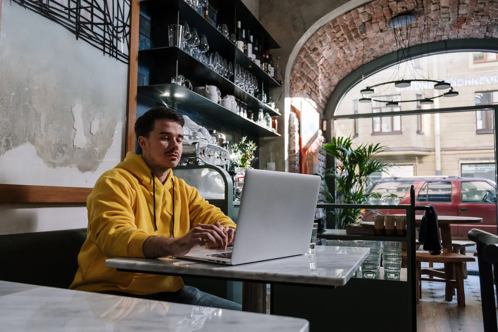 Télétravailleur sur ordinateur portable dans un café lumineux