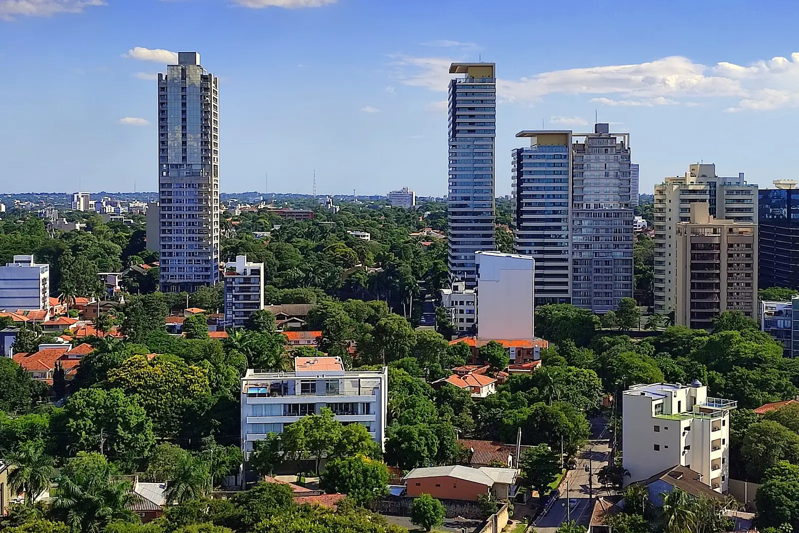 Immeubles résidentiels et maisons à toits de tuiles dans un quartier arboré d'Asunción, Paraguay