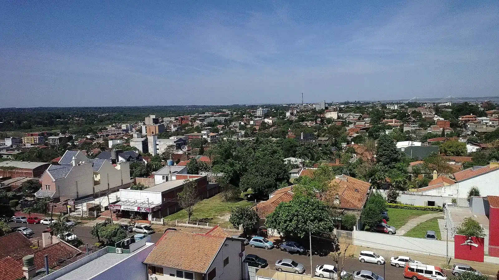 Vue aérienne du quartier résidentiel Juan León Mallorquín à Encarnación : maisons à toits de tuiles, petits immeubles et rues bordées de voitures