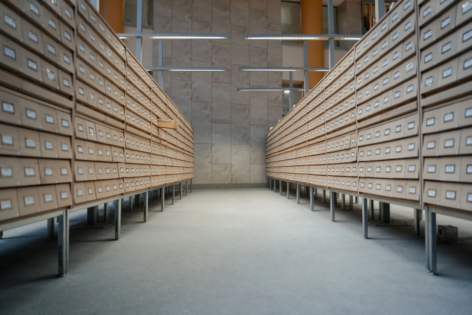 Allée d'archives bordée de meubles à tiroirs étiquetés (photo d'illustration)