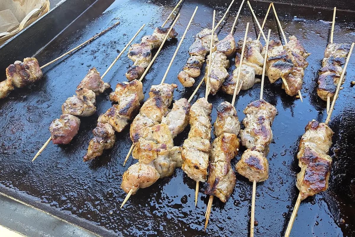 Asadito paraguayo : brochettes de viande grillées sur une plancha dans un stand de rue d'Encarnación, Paraguay
