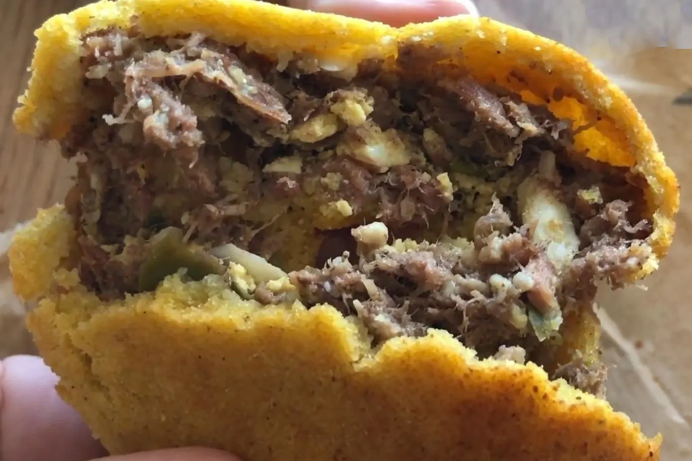 Chipa so'o coupée en deux, pâte de maïs jaune farcie de viande effilochée et d'œuf, Paraguay
