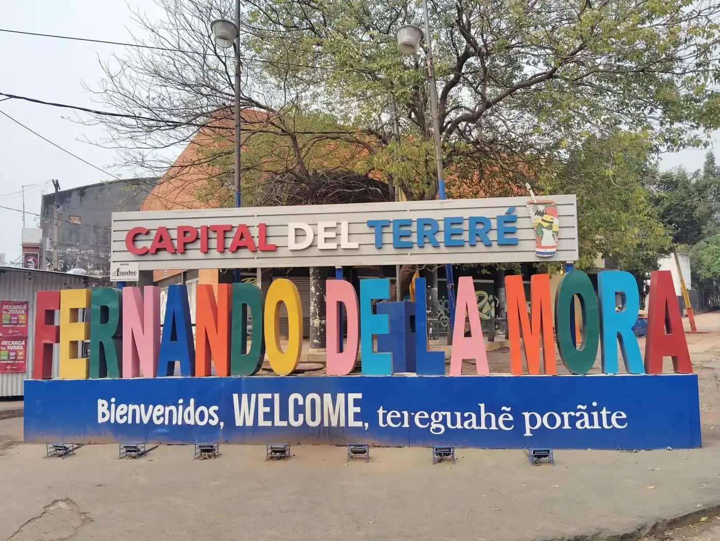 Grand panneau coloré « Fernando de la Mora, capitale du tereré » avec le message de bienvenue en espagnol, en anglais et en guarani : Bienvenidos, WELCOME, tereguahẽ porãite