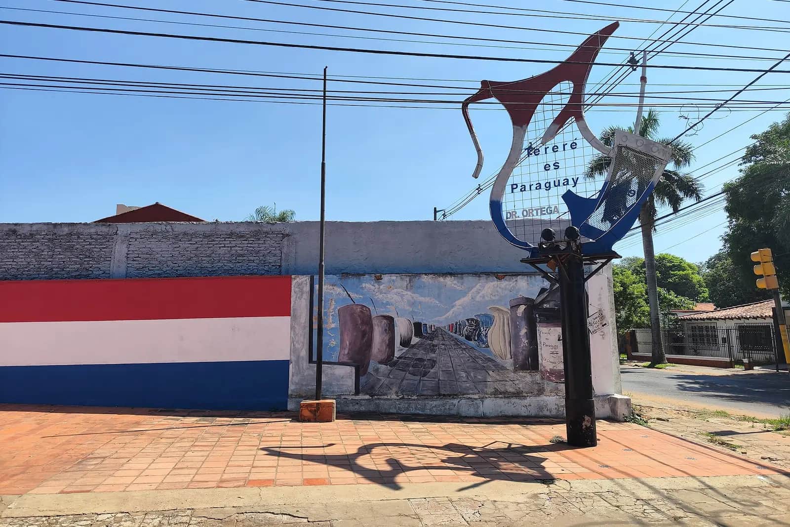 Monument « Tereré es Paraguay » en forme de termo et de guampa, devant une fresque aux couleurs du drapeau paraguayen, à Fernando de la Mora