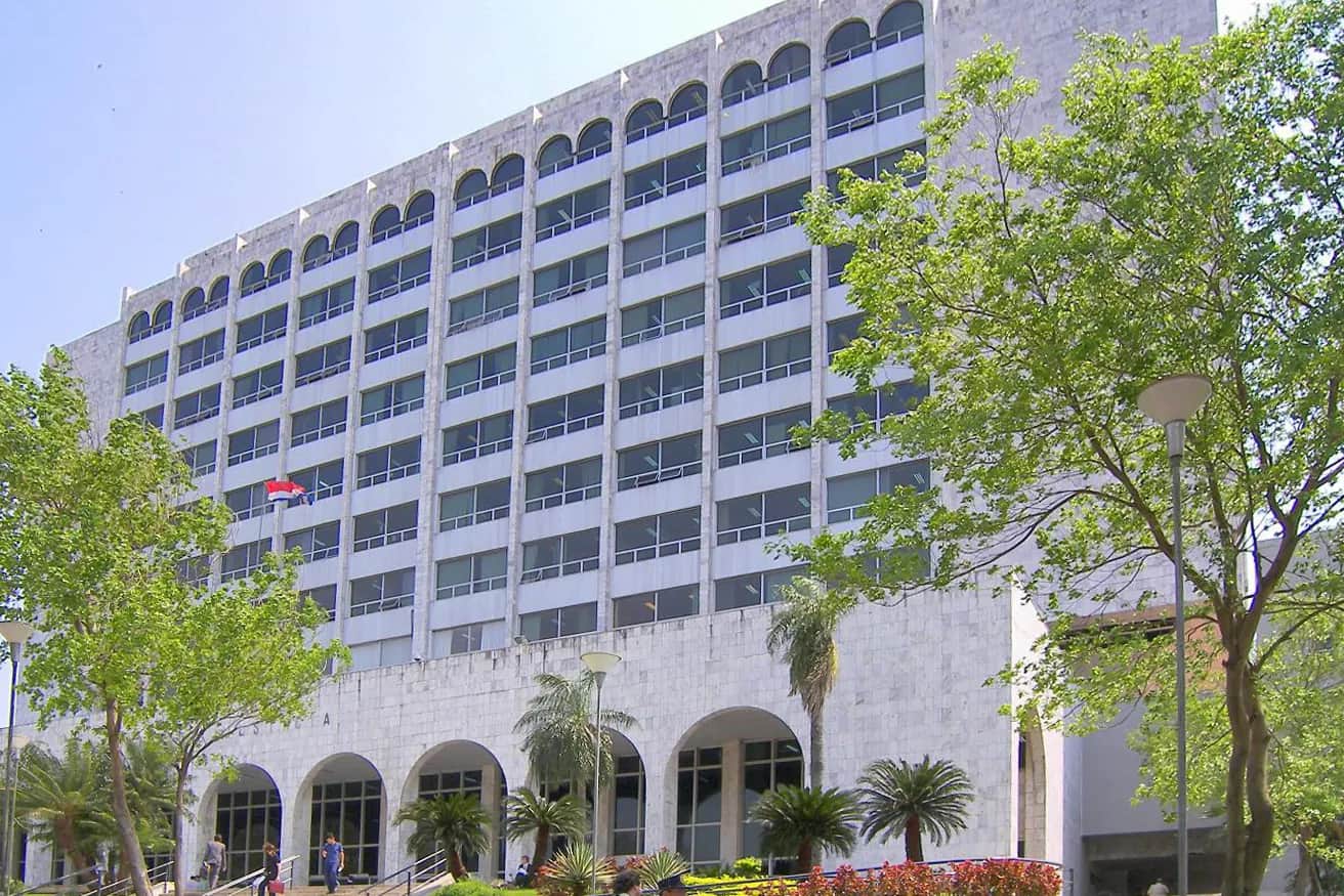Façade en marbre blanc du Palacio de Justicia d'Asunción, siège de la Corte Suprema de Justicia du Paraguay, avec ses arcades et ses palmiers