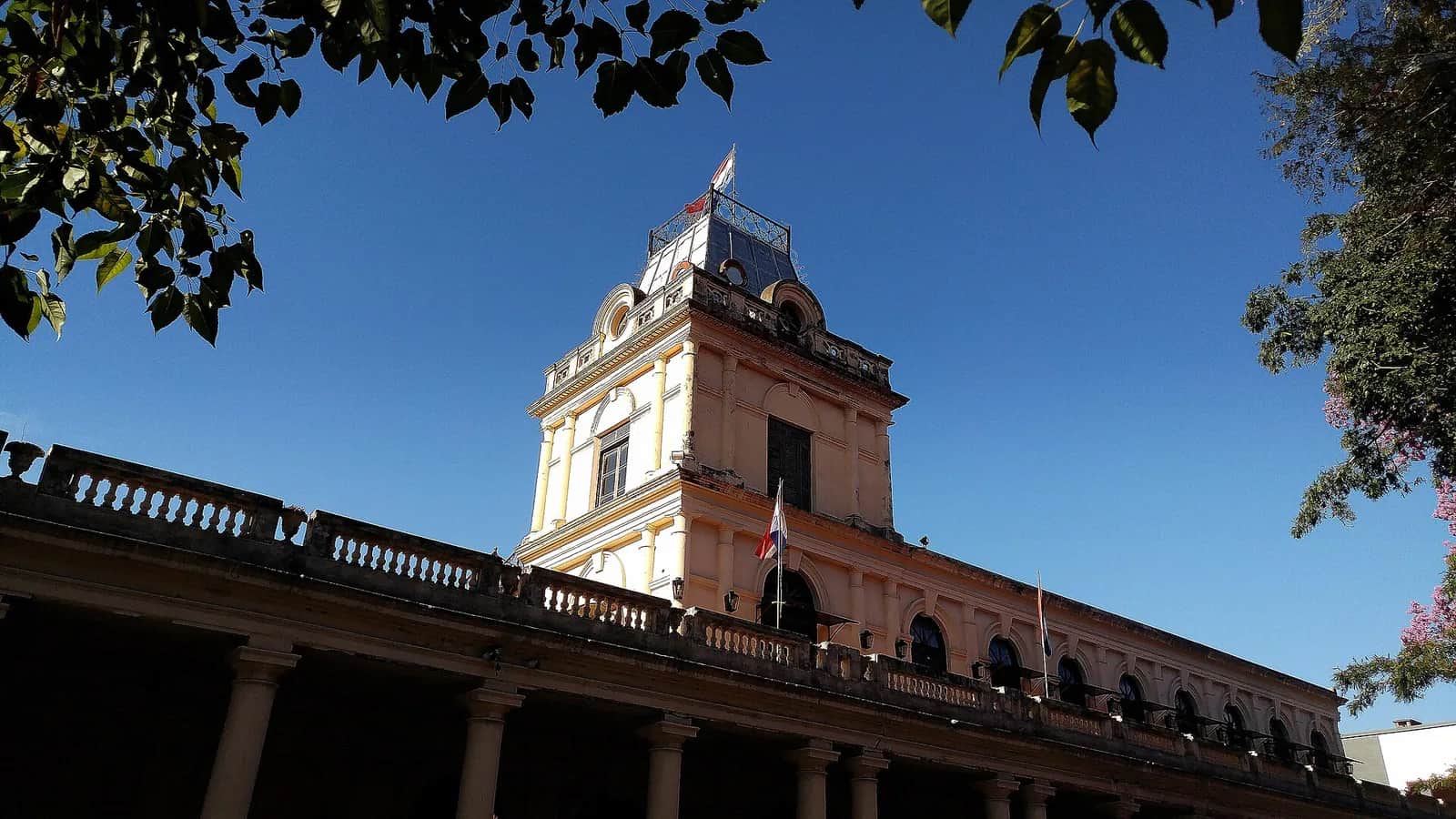 Tour de l'ancienne gare centrale (Estación Central del Ferrocarril) d'Asunción, sous un ciel bleu, avec le drapeau paraguayen