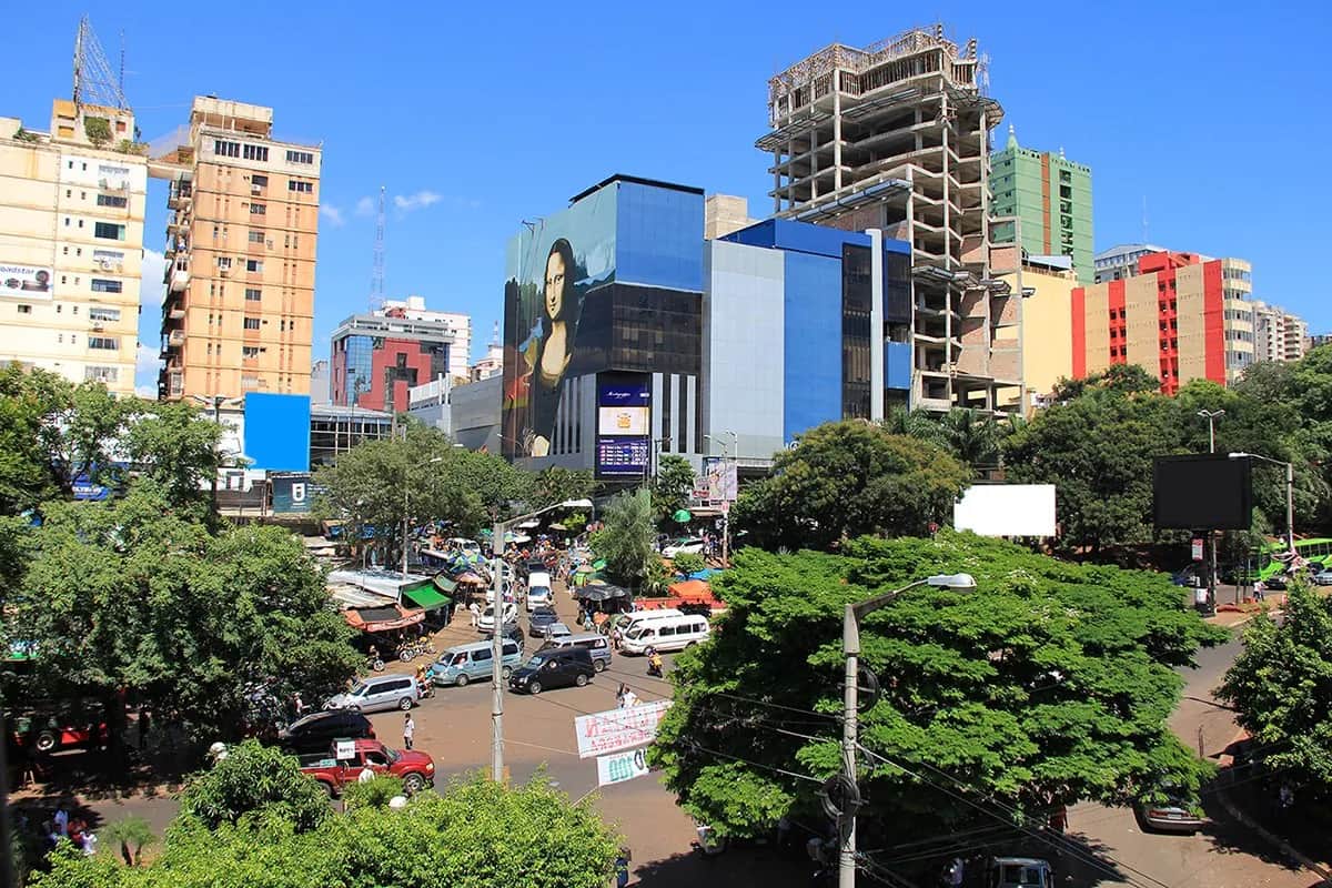Avenue du centre de Ciudad del Este, au Paraguay, avec ses immeubles de bureaux et de commerces, une fresque de la Joconde sur une façade vitrée et la circulation en contrebas