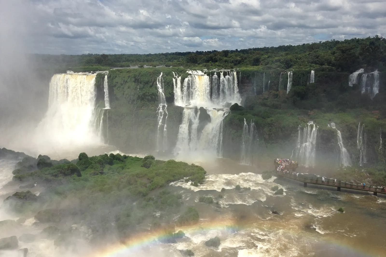Chutes d’Iguaçu vues du côté brésilien, avec la passerelle des visiteurs, un arc-en-ciel et la brume, au parc national d’Iguaçu