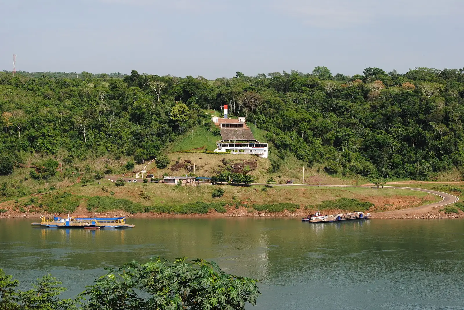 Monument paraguayen de la triple frontière, sur la rive du Paraná à Presidente Franco, avec les bacs à quai, vu depuis l’Argentine