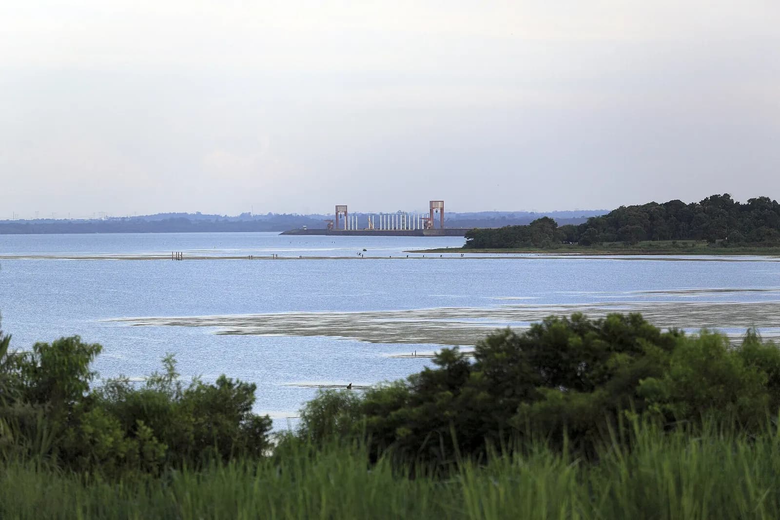 Le lac de retenue d'Itaipú vu depuis la Costanera de Hernandarias, avec la crête du barrage au loin