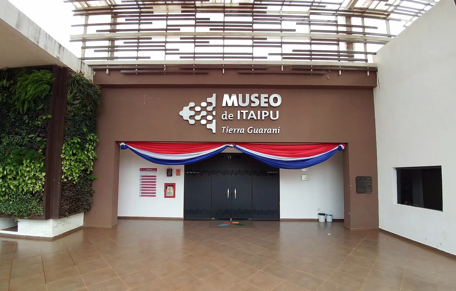 L'entrée du Museo de Itaipu Tierra Guaraní, avec son enseigne et un drapé aux couleurs du Paraguay