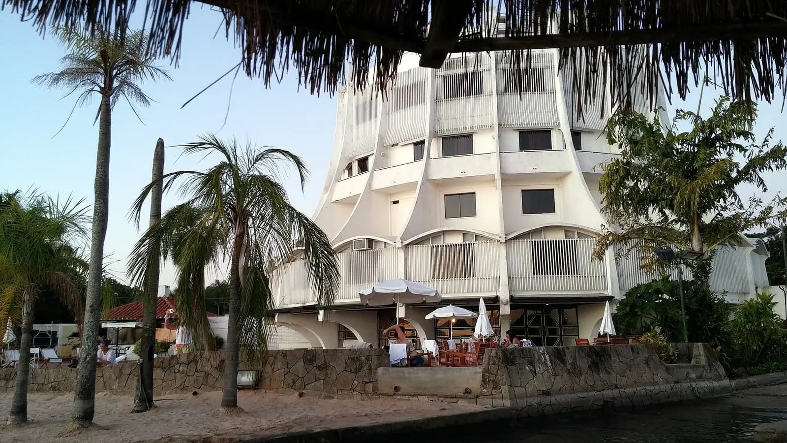 Hôtel blanc avec terrasse sous les palmiers à San Bernardino, Paraguay