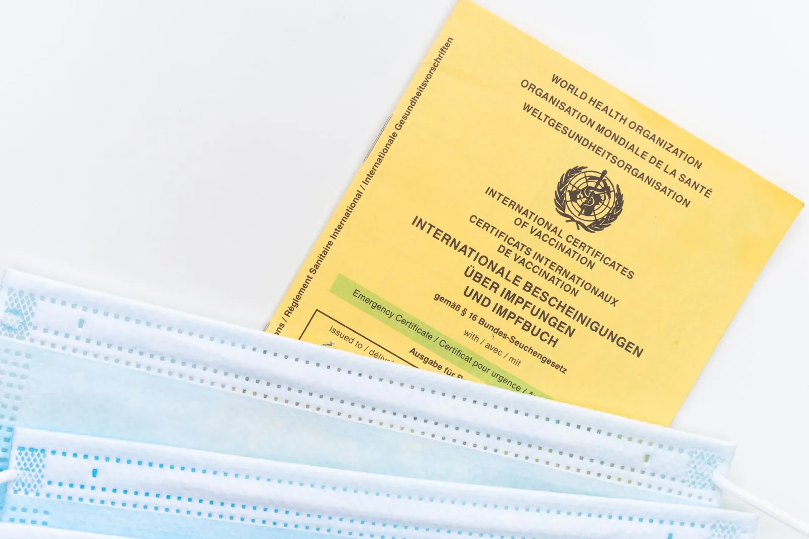 Carnet international de vaccination de l'OMS posé près de masques chirurgicaux
