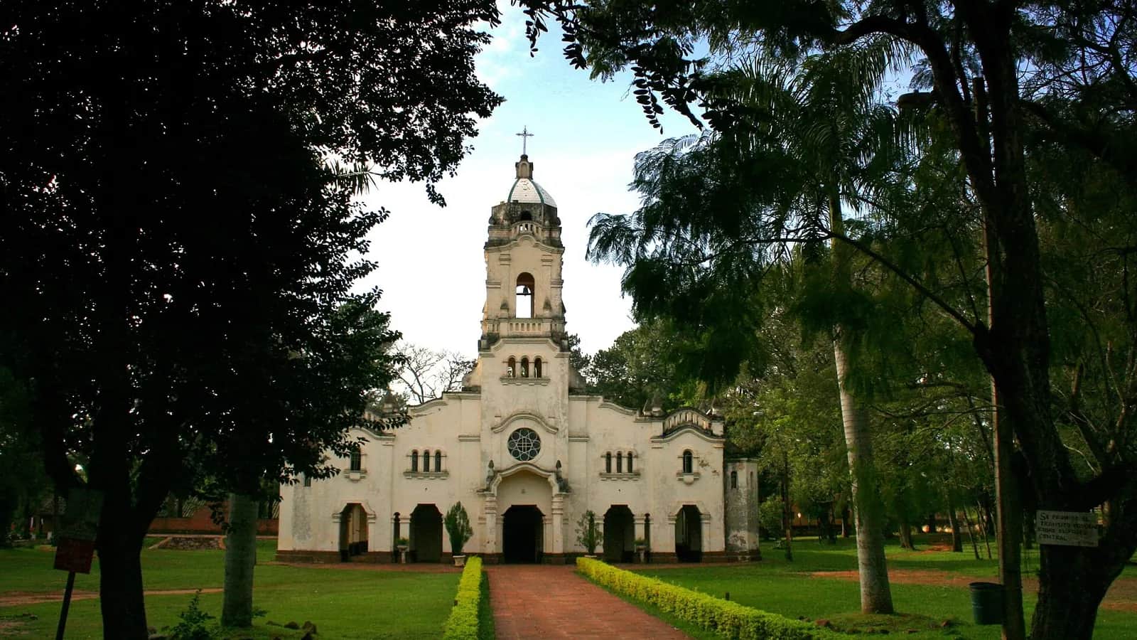 Église blanche de San Ignacio Guazú au bout d'une allée de briques, entre de grands arbres, dans le département de Misiones, ancienne réduction jésuite